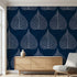 Close-up of the Traces floral mural on a wall showing blue leaves and seamless pattern in a modern living room setting.