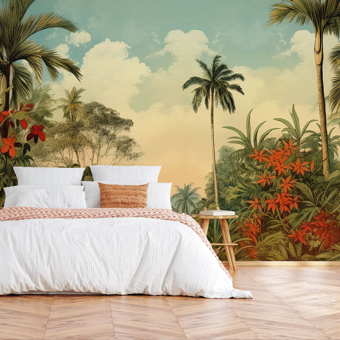 Vintage tropical mural with palm trees, lush green foliage and red orange flowers beneath a soft blue sky, displayed on the wall behind a neatly made bed with white linens and a orange throw blanket, set in a bedroom with wooden flooring.