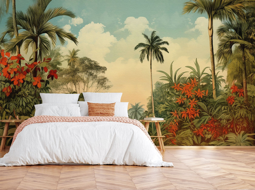 Vintage tropical mural with palm trees, lush green foliage and red orange flowers beneath a soft blue sky, displayed on the wall behind a neatly made bed with white linens and a orange throw blanket, set in a bedroom with wooden flooring.