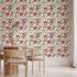 Floral wallpaper featuring hand painted tulips, buds, and delicate blossoms in berry, blush, cream, and soft green tones on a white background, inspired by classic botanical illustrations. This wallpaper is in a dinning room with light wood furniture.