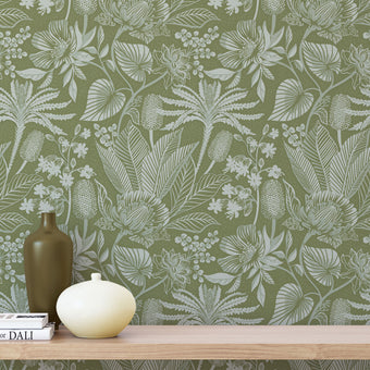 Floral green wallpaper with a wooden shelf and decorative items in the foreground