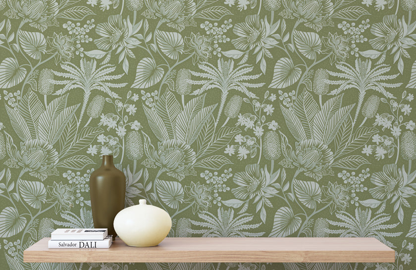 Floral green wallpaper with a wooden shelf and decorative items in the foreground
