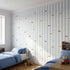Vivid mural in a young boy's bedroom with blue, white, yellow, and red striped wallpaper featuring cars.
