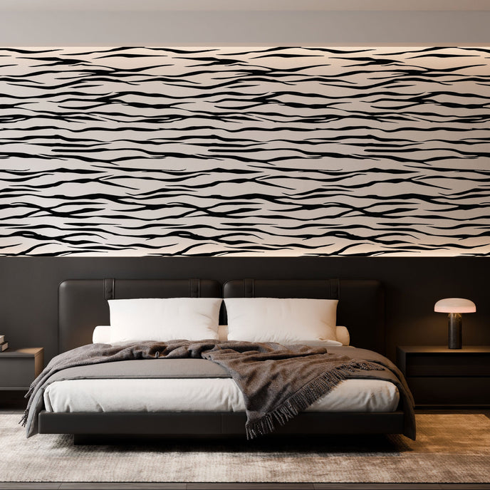 A modern bedroom featuring a horizontal zebra stripe wallpaper with a seamless repeat, featuring flowing black stripes on a white background in a bold animal-inspired pattern. With a low bed with grey bedding and dark bedside tables.

