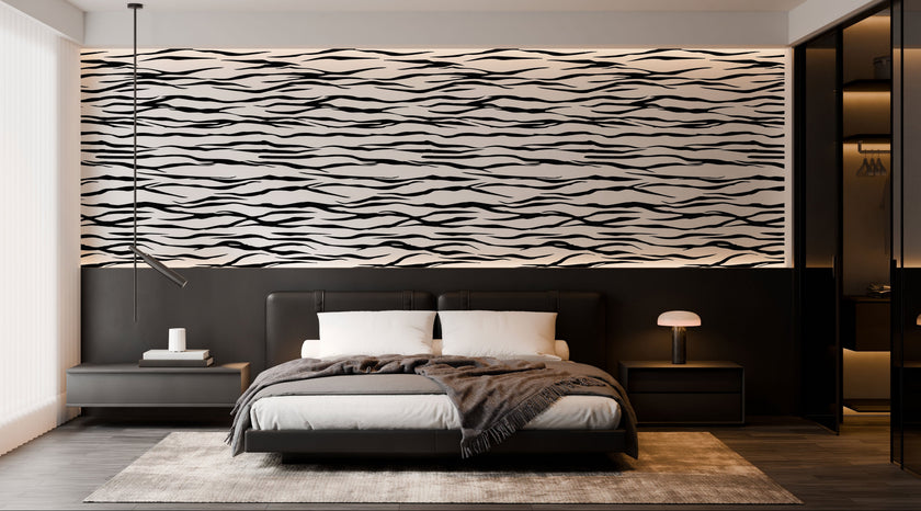 A modern bedroom featuring a horizontal zebra stripe wallpaper with a seamless repeat, featuring flowing black stripes on a white background in a bold animal-inspired pattern. With a low bed with grey bedding and dark bedside tables.

