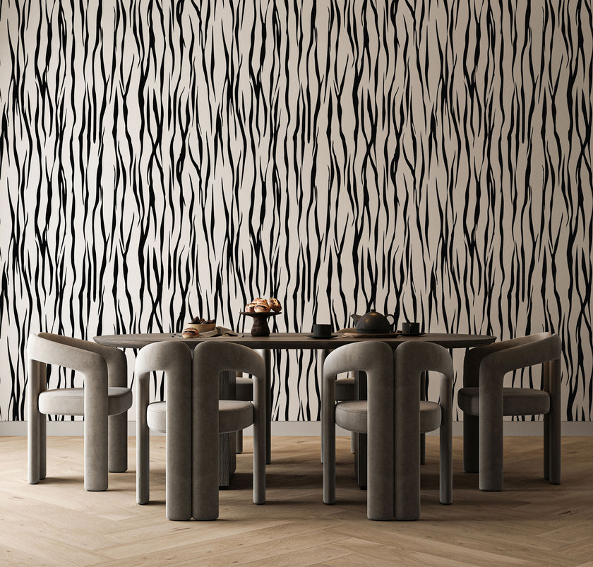 A dining set featuring a rectangular wooden table and six curved grey chairs, set against a bold black and white vertical zebra stripe wallpaper with a seamless repeat, featuring flowing black stripes on a white background in a bold animal inspired pattern, and light wood herringbone flooring.


